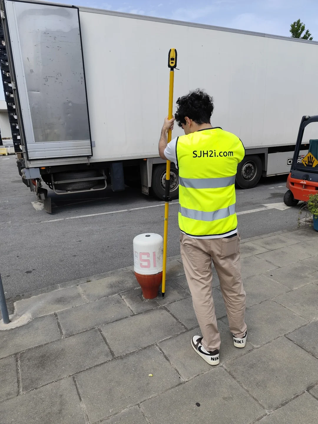 Técnico da SJH2i com equipamento de levantamento no terreno